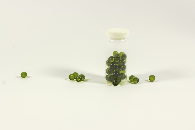 Tabletky v tvare zelených guličiek v sklenenej fľaštičke.jpg